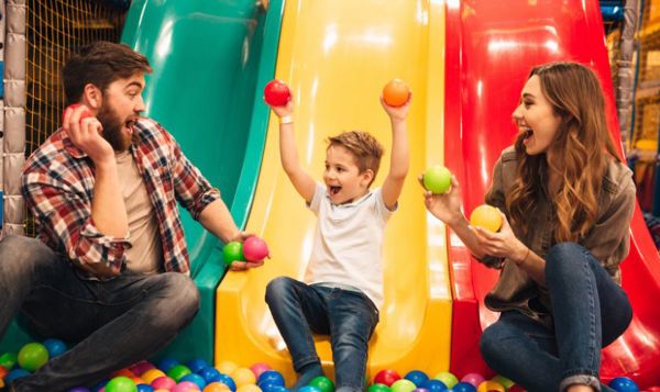 Parents and child playing at soft play as a rainy-day indoor activity
